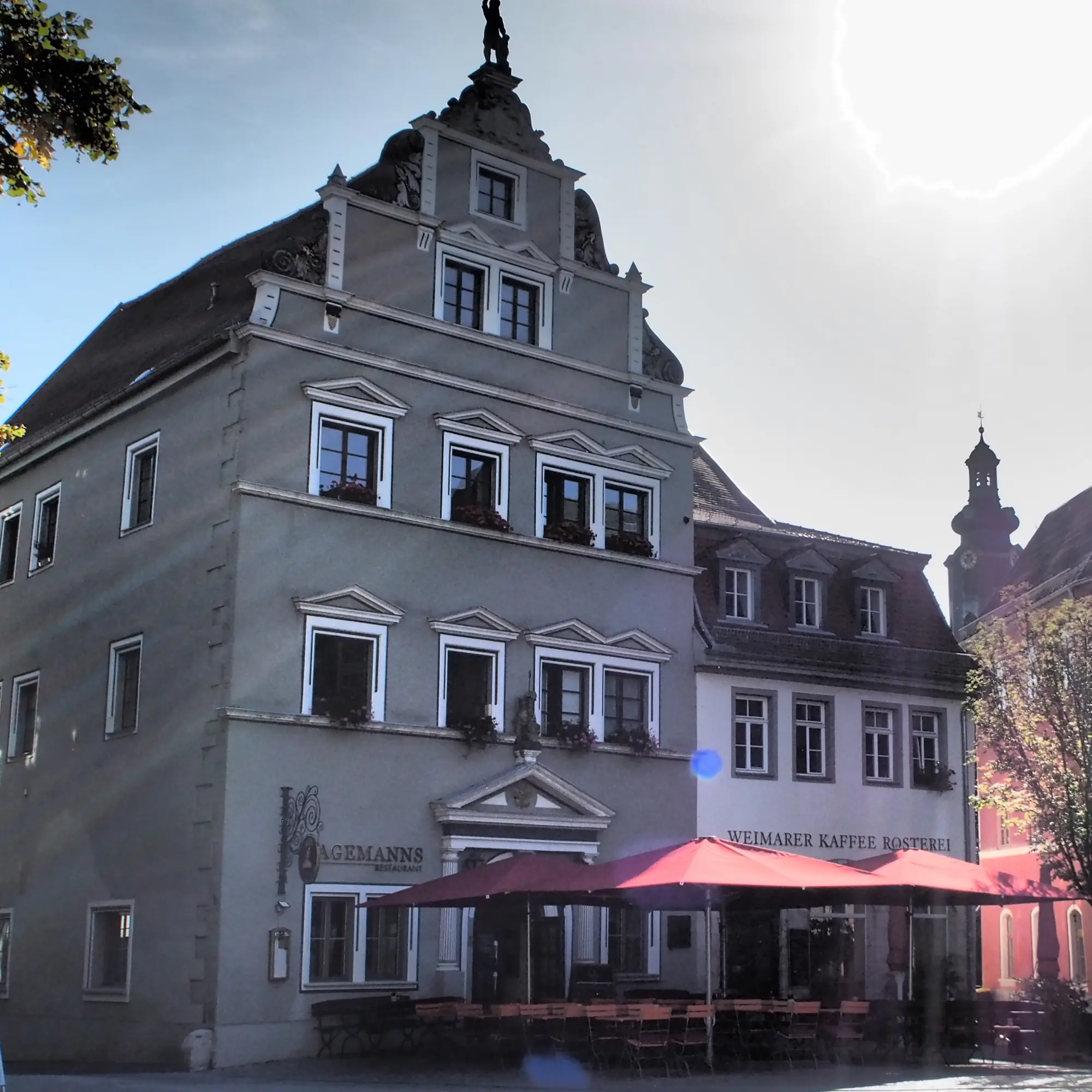 Restaurant Jagemanns am Herderplatz in der Innenstadt von Weimar, Außenansicht Terrasse mit roten Sonnenschirmen